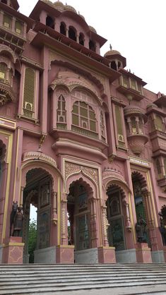 an ornate pink building with steps leading up to it