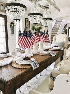 a dining room table with american flags on it and place settings in front of the table