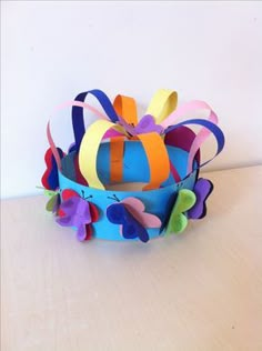 a colorful paper flower arrangement sitting on top of a wooden table