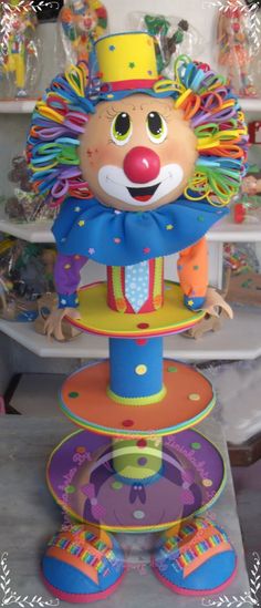 a colorful clown statue sitting on top of plates