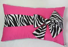 a pink pillow with zebra print on it and a black ribbon tied to the front