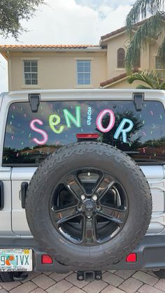 a white truck parked in front of a house with the word senior on it's side