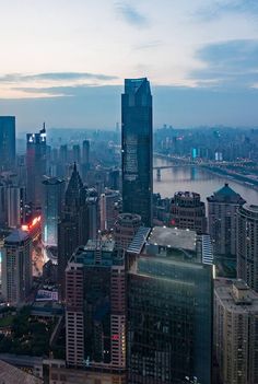 an aerial view of the city skyline at dusk, with skyscrapers lit up in red