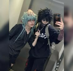 two people with blue hair taking a selfie in the bathroom mirror while one person takes a photo