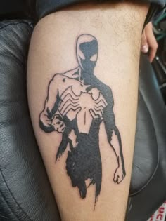 a man with a spider - man tattoo on his leg is shown in black and white