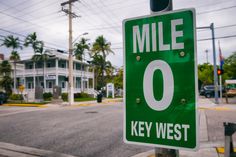 a green mile sign sitting on the side of a road next to a traffic light