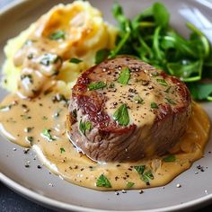 a white plate topped with meat covered in gravy