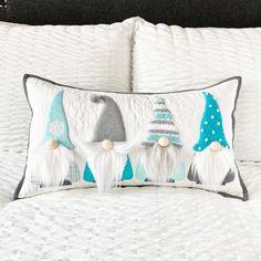 a white bed topped with pillows and two gnomes