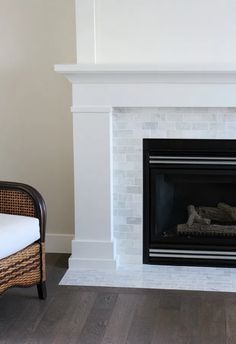 an empty living room with a fireplace and chair