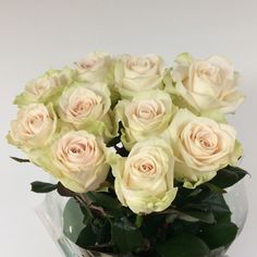 a vase filled with white roses on top of a table