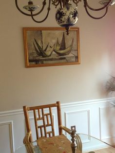 a chandelier hangs from the ceiling above a dining room table with two chairs