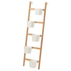 a wooden ladder with three white buckets on it and one is holding two cups