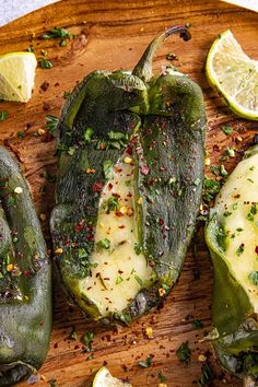 some green peppers on a wooden cutting board with lemon slices and seasoning sprinkles