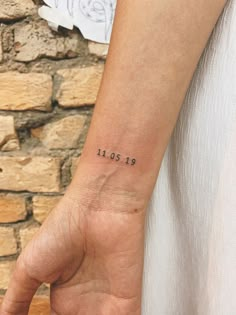 a person with a small wrist tattoo on their left arm and the date 1911 in black ink