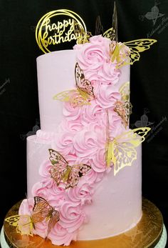 a white cake with pink flowers and butterflies on top