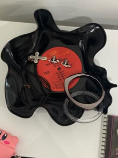 a record and ring holder on top of a table next to a pink piggy bank