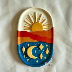 a ceramic sun and moon dish on a white sheet