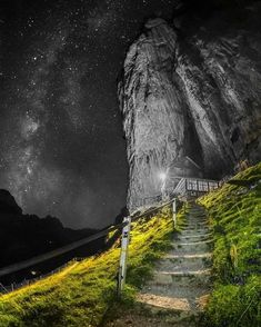 stairs leading up to the top of a mountain at night with stars in the sky