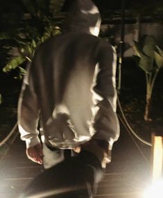 a man riding a skateboard down a street at night with the light shining on him