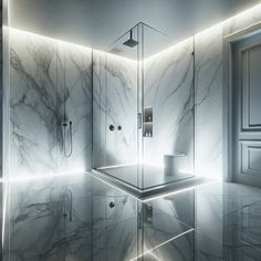 a bathroom with marble walls and flooring is lit up by lighting from the ceiling