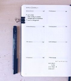 an open notebook with writing on it next to a pen