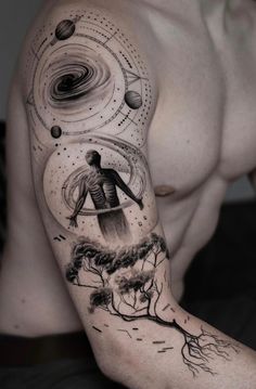 a man's arm with an image of planets and a tree on the side