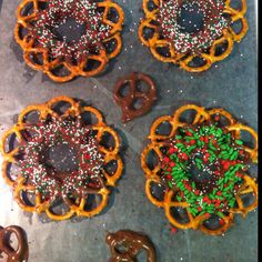 four pretzels with chocolate and sprinkles on them