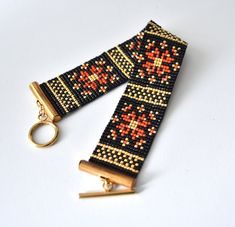 a pair of black and red beaded bracelets on a gold keychain