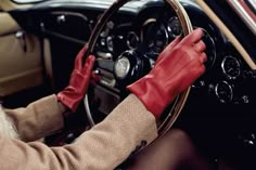 a person wearing red gloves driving a car