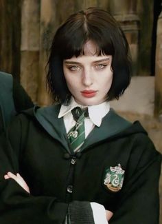 a woman in a harry potter costume with her arms crossed, looking at the camera