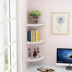 a desk with a computer, books and doll figurines on it in front of a window