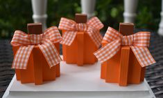 small orange boxes with bows on them sitting on a table