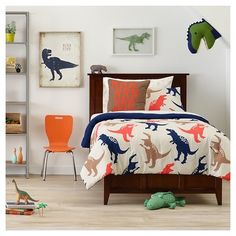 a child's bedroom with dinosaur bedding and toys