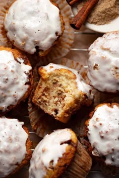 cinnamon muffins with white frosting and cinnamon sticks