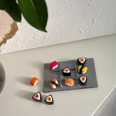 sushi on a tray next to a potted plant and some other food items