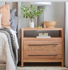 a bed room with a neatly made bed and a night stand