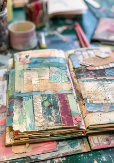 an open book sitting on top of a table covered in lots of different colored papers