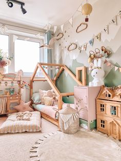 a child's bedroom decorated in pastel colors and wooden furniture, including a doll house