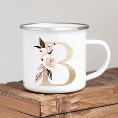 a white and gold coffee mug with flowers on it