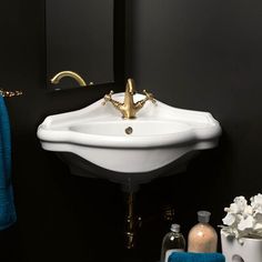 a white sink sitting under a mirror next to a blue towel and soap dispenser