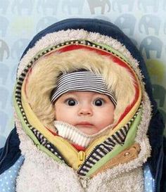 a baby doll wearing a blue jacket and scarf