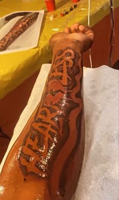 a hot dog with writing on it sitting on top of a table