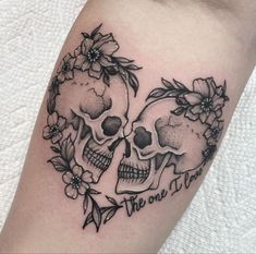 two skulls with flowers on their heads and the words, we are one in them