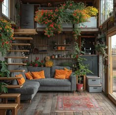 a living room filled with furniture and lots of flowers hanging from the ceiling next to windows