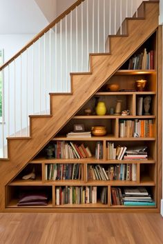 a bookshelf under the stairs is full of books