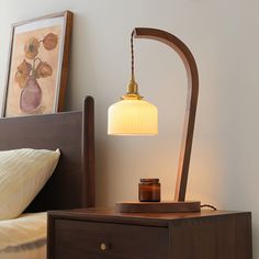 a lamp on a night stand next to a bed