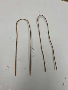 two pairs of gold - plated metal earwires on a white table top