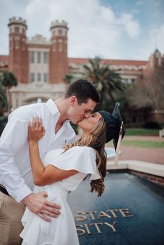 a man and woman kissing in front of the stately building with palm trees behind them