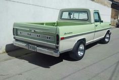 an old pick up truck is parked on the side of the road