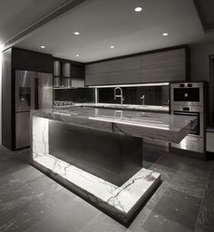 a large kitchen with marble counter tops and stainless steel appliances